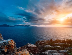 Dramatic sunset on the coastline. Motion clouds on horizon, rainy weather